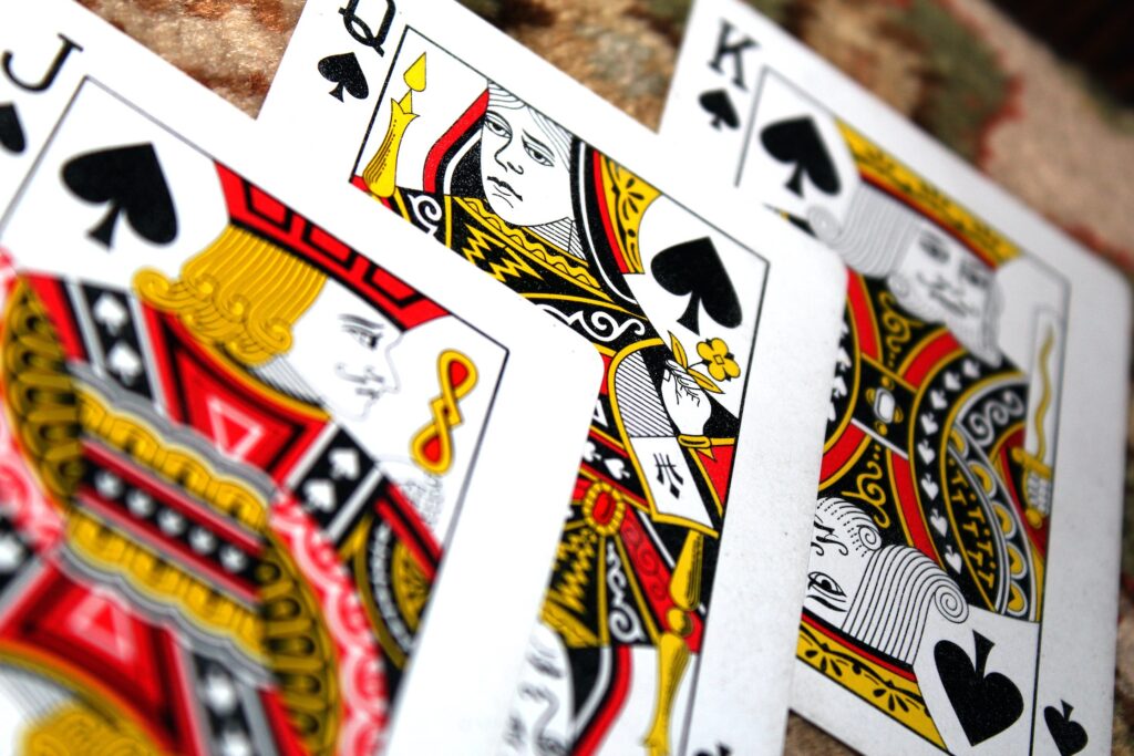 A close up of three playing cards; the Jack, the queen and the king of spades