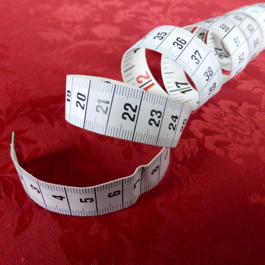 A spooled measuring tape against a red velvet background 