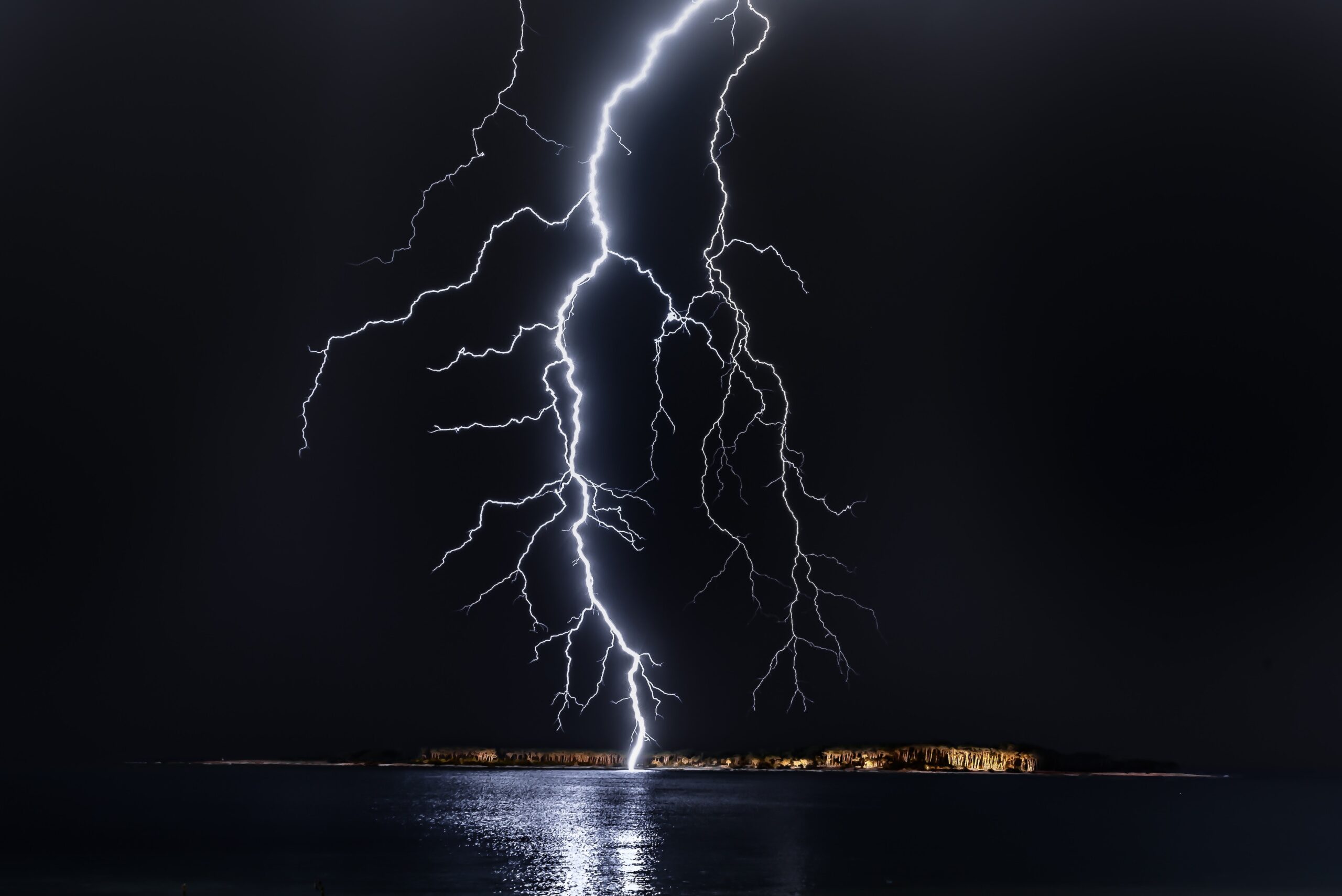 lightning striking the ocean at night