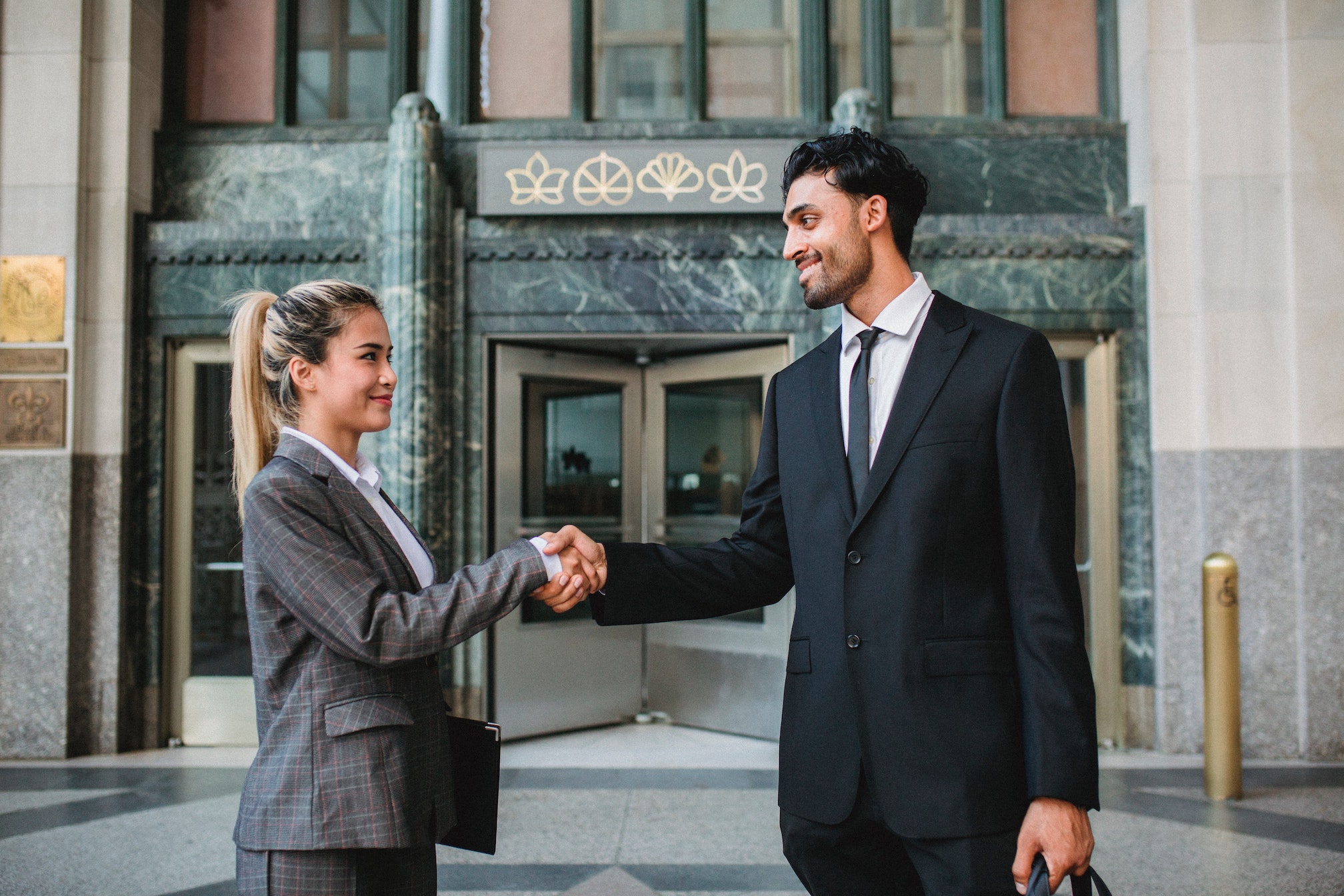 two young business professionals shaking hands