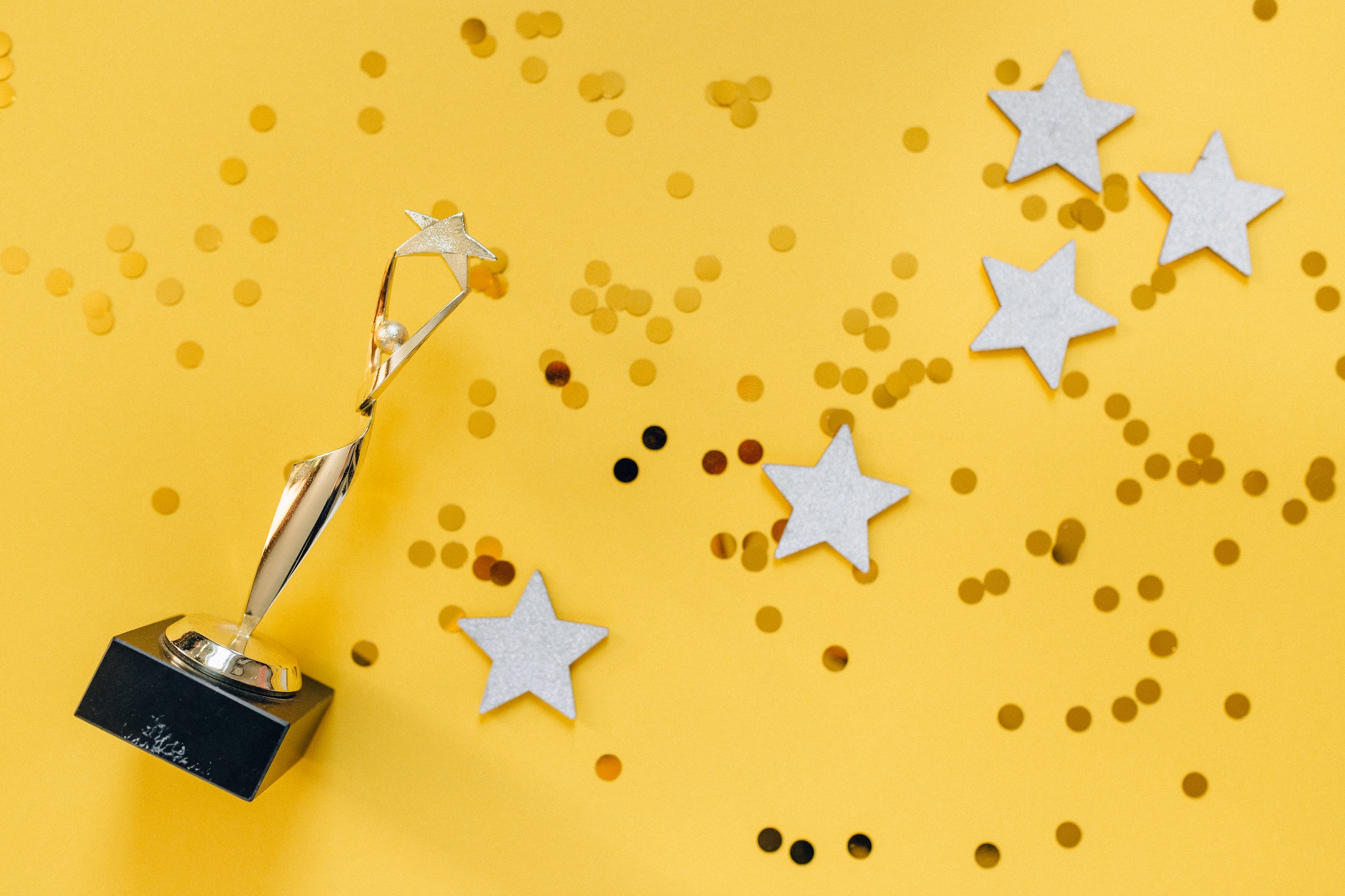 golden trophy and silver stars on a yellow background