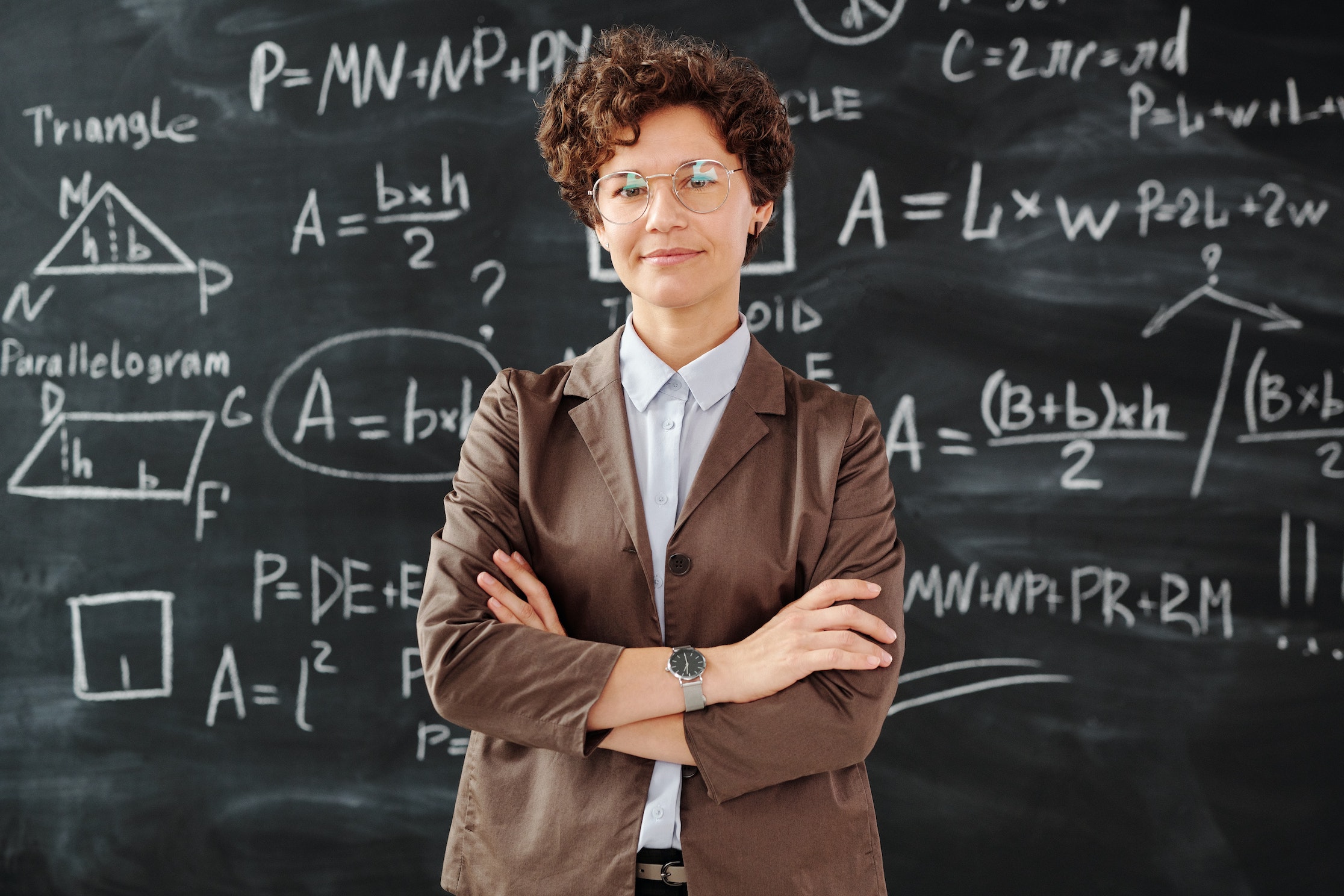 woman in business suit in front of a blackboard