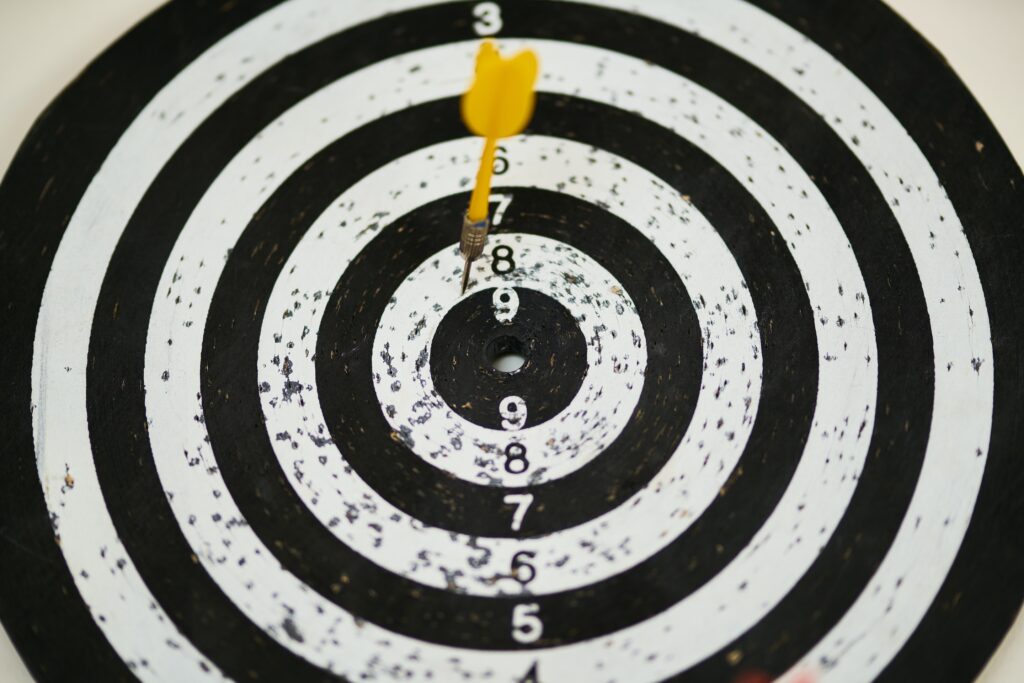 A dartboard with a yellow dart in the white 8 ring 