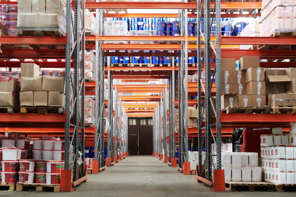 Inventory is stacked on a shelf in an orange Amazon warehouse.