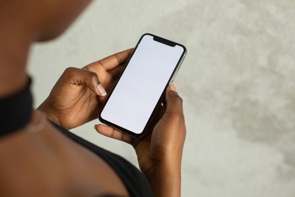 A close up view of a black man's hands holding an apple iphone