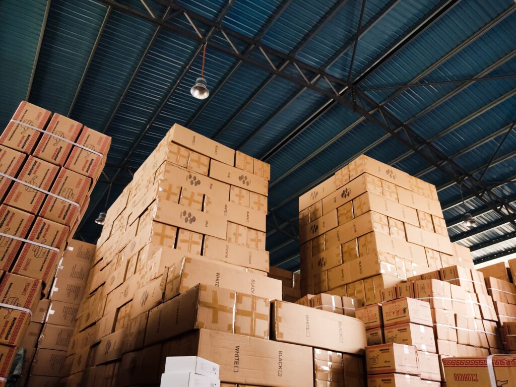 A large warehouse full of brown, stacked cardboard boxes 
