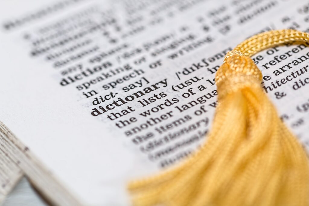 A close up view of a dictionary with a bright gold corded placeholder
