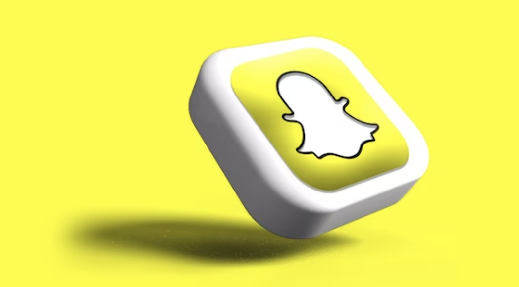The Snapchat logo on a small button in front of a yellow background
