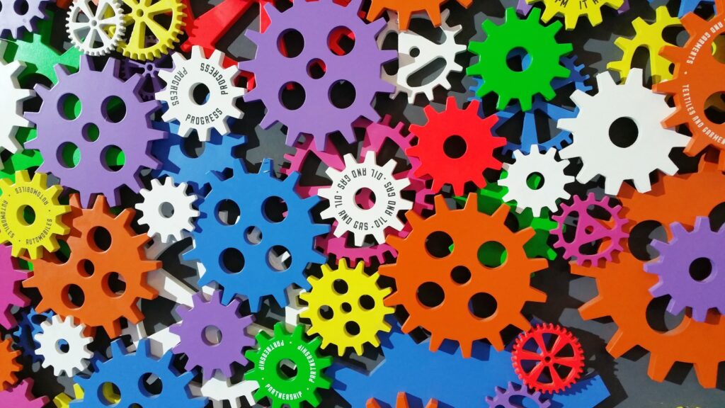 A variety of 30, or more different colored gears jumbled together