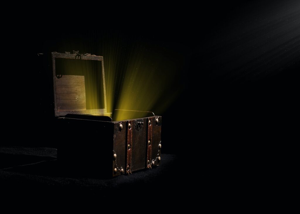 A mysterious open wooden box with light rays shining upward out of the interior