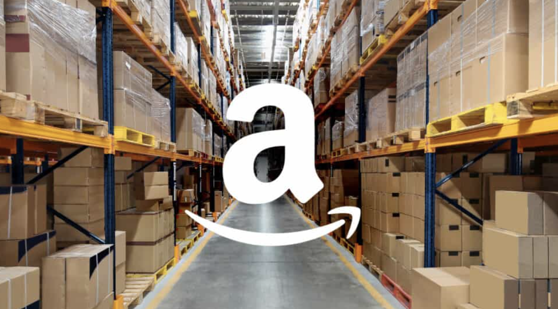 A view of boxes on shelves at an Amazon warehouse with the Amazon "a" logo overlayed in the center of the screen.