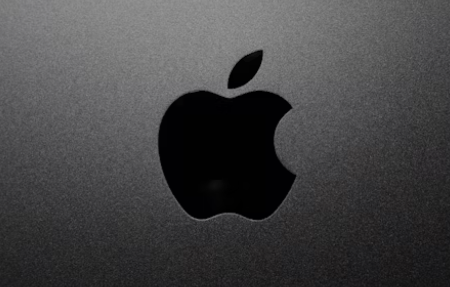 A top down view of the black Apple logo on a silver laptop 