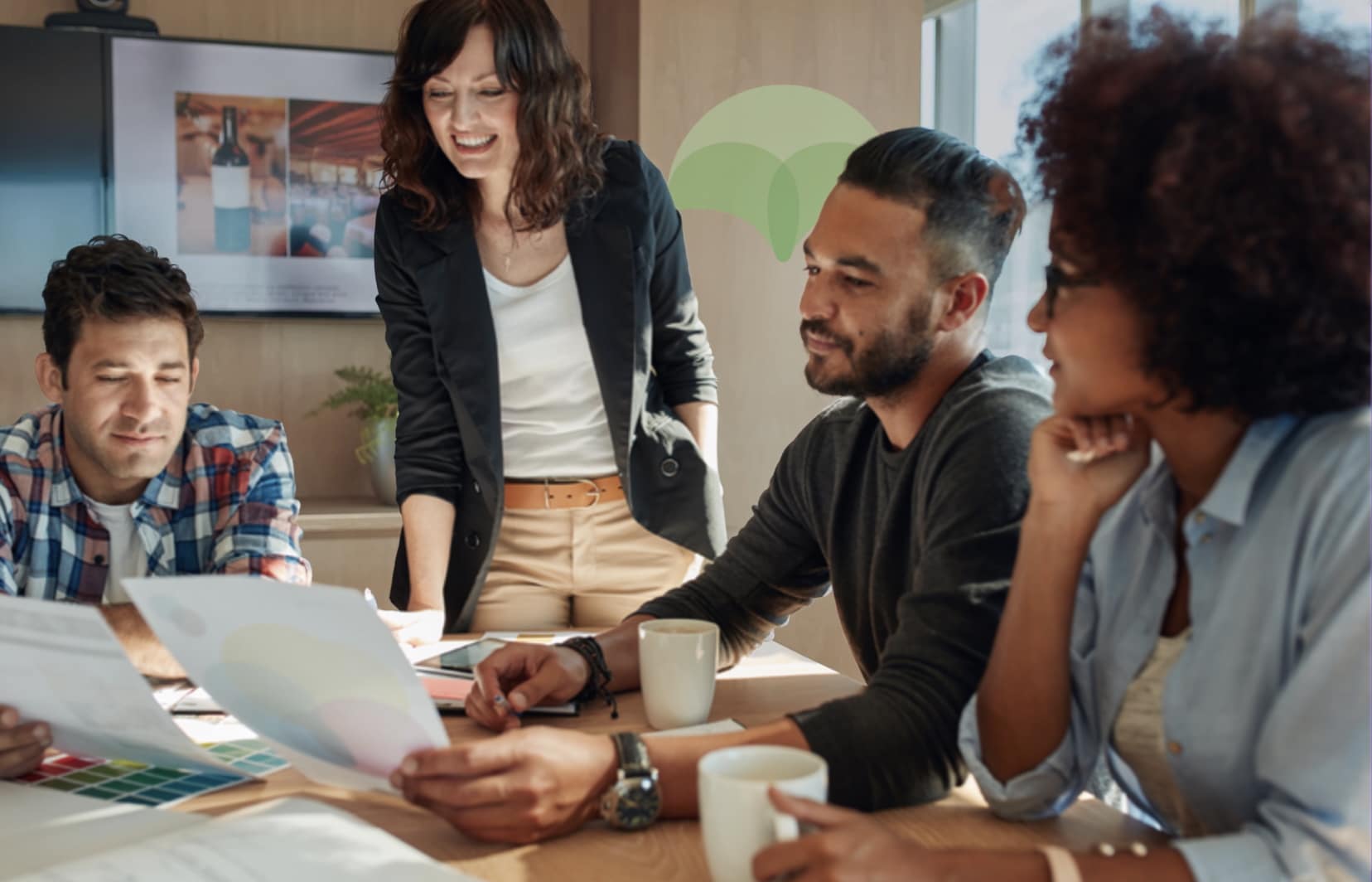 A group of 4 young ecommerce professionals, two men and two women discussing strategy at a table in a casual, stylish office