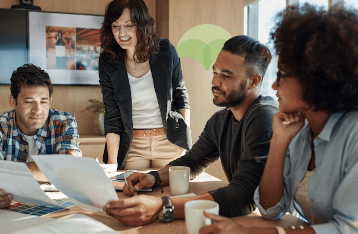 A team of ecommerce professionals are at a desk talking about strategy