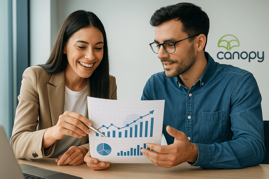 a landscape mode image of two ecommerce sellers lookin g at a chart in a modern office with a small Canopy Management logo on the wall