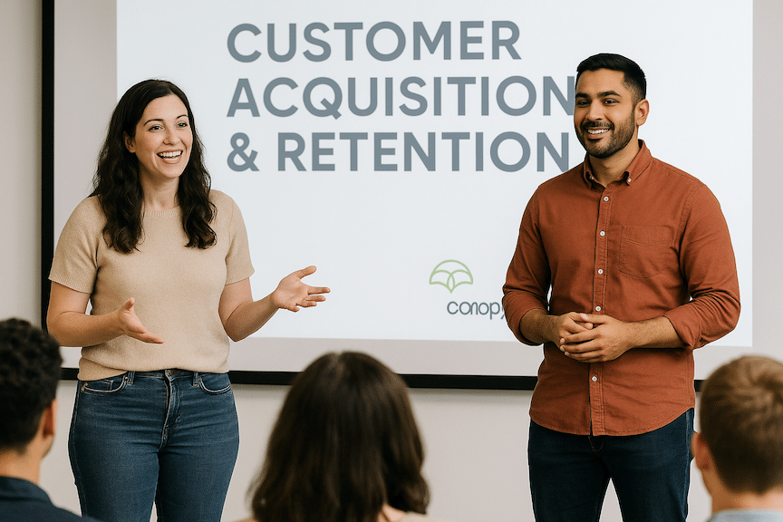 Two entrepreneurs presenting a talk on Customer Acquisition & Retention in front of an audience with a small canopy management logo on the wall
